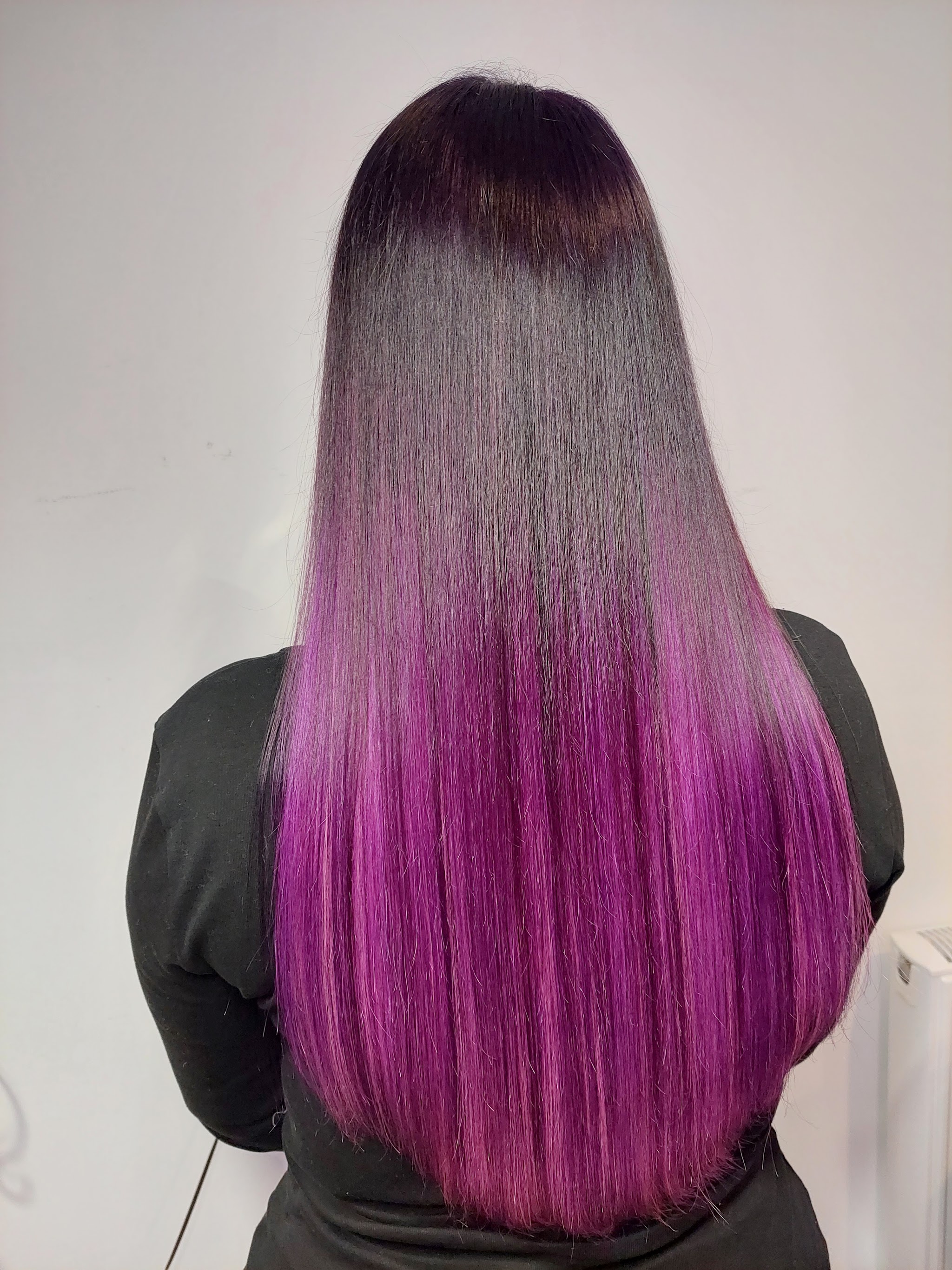 Long straight hair coloured from dark roots to a deep magenta and purple