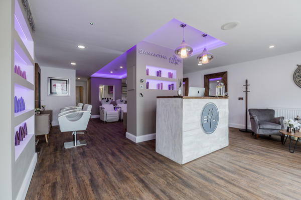 A wide view of the salon from the waiting chairs to the reception and styling stations